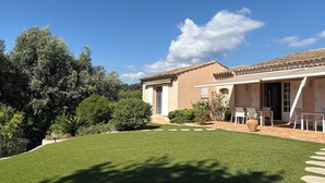 A house with a patio, a lawn, and a garden. - Dream villa with sea view and private pool in the gulf of Saint-Tropez (Grimaud)