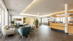 A spacious lobby with modern furniture, a reception desk, and large windows. - Superior vacation home with gallery (St. Georgen am Kreischberg)