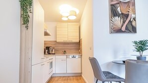 A compact kitchen with white cabinets, a wooden countertop, and a modern pendant light. - Nice 1BR 1LR Apartment City Center (Vienna)