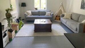 A living room with a sofa, a coffee table, a lamp, a window, and a teepee. - 5 Star Holiday Home in Vaxholm (Vaxholm)