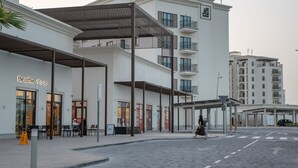 Een modern gebouw met een café genaamd 'The Coffee' op de begane grond.