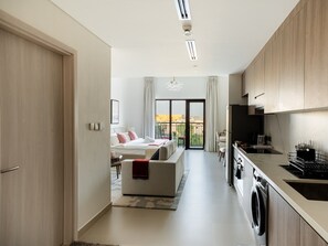 Eine moderne Wohnung mit Küche, Essbereich und einem Schlafzimmer mit Balkon.