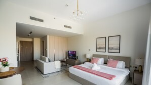 Een moderne hotelkamer met een groot bed, een televisie, een bank en een eethoek.