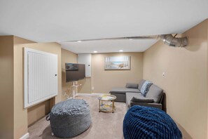A cozy living room with a sofa, a television, a cabinet, and a small table. - Tusculum Hilltop Haven  For 8 (Cincinnati)