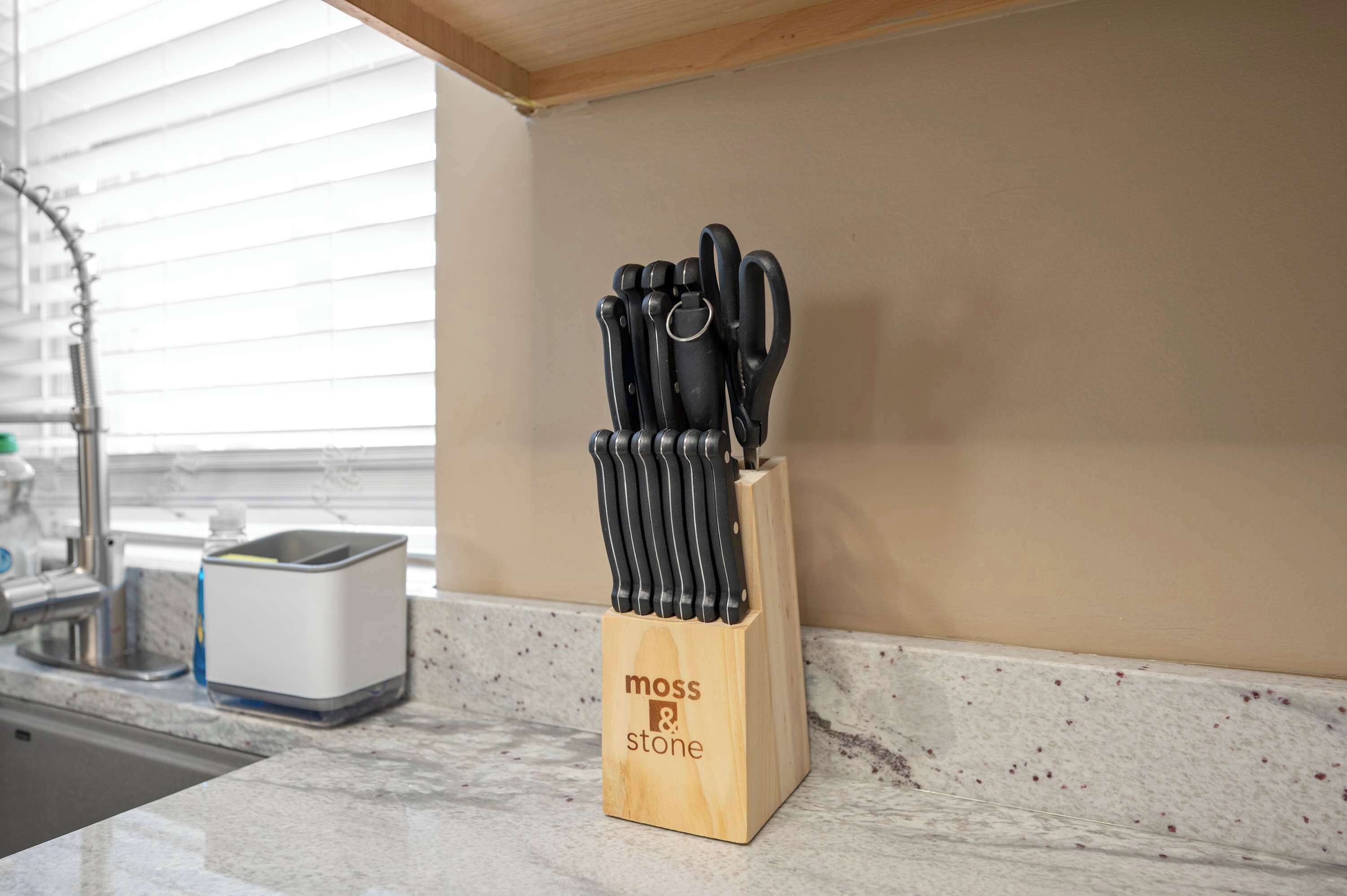 A kitchen counter with a knife block labeled "moss & stone" and a toaster.