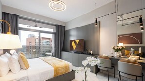 A modern hotel room with a large bed, a desk, and a dining area. - Vogue| Downtown close to Burj Khalifa | Dubai Mall (Dubai)