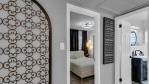 A hotel room with a bed, a nightstand, and a wall with a list of Parisian landmarks. - Backyard Zen  Retreat with Modern Vibe (Tampa)