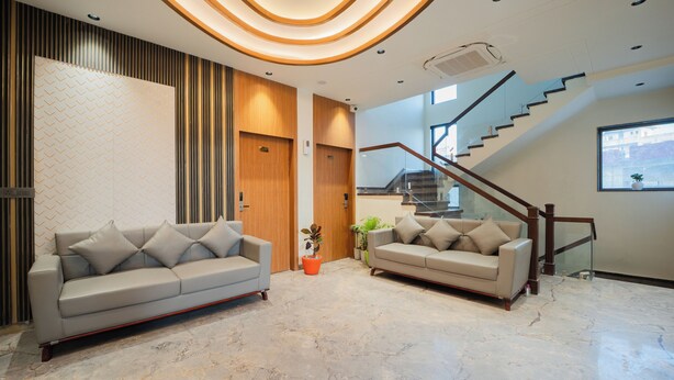 Een modern interieur met twee banken, een trap en een behang met patroon.
