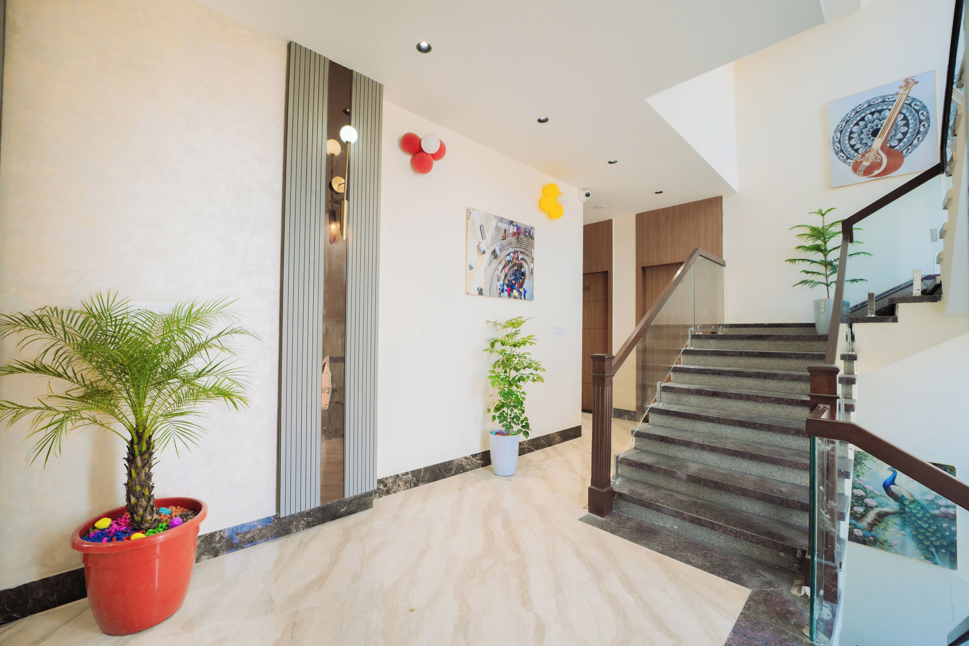 Un interior moderno con suelo de mármol, una escalera y plantas en macetas.