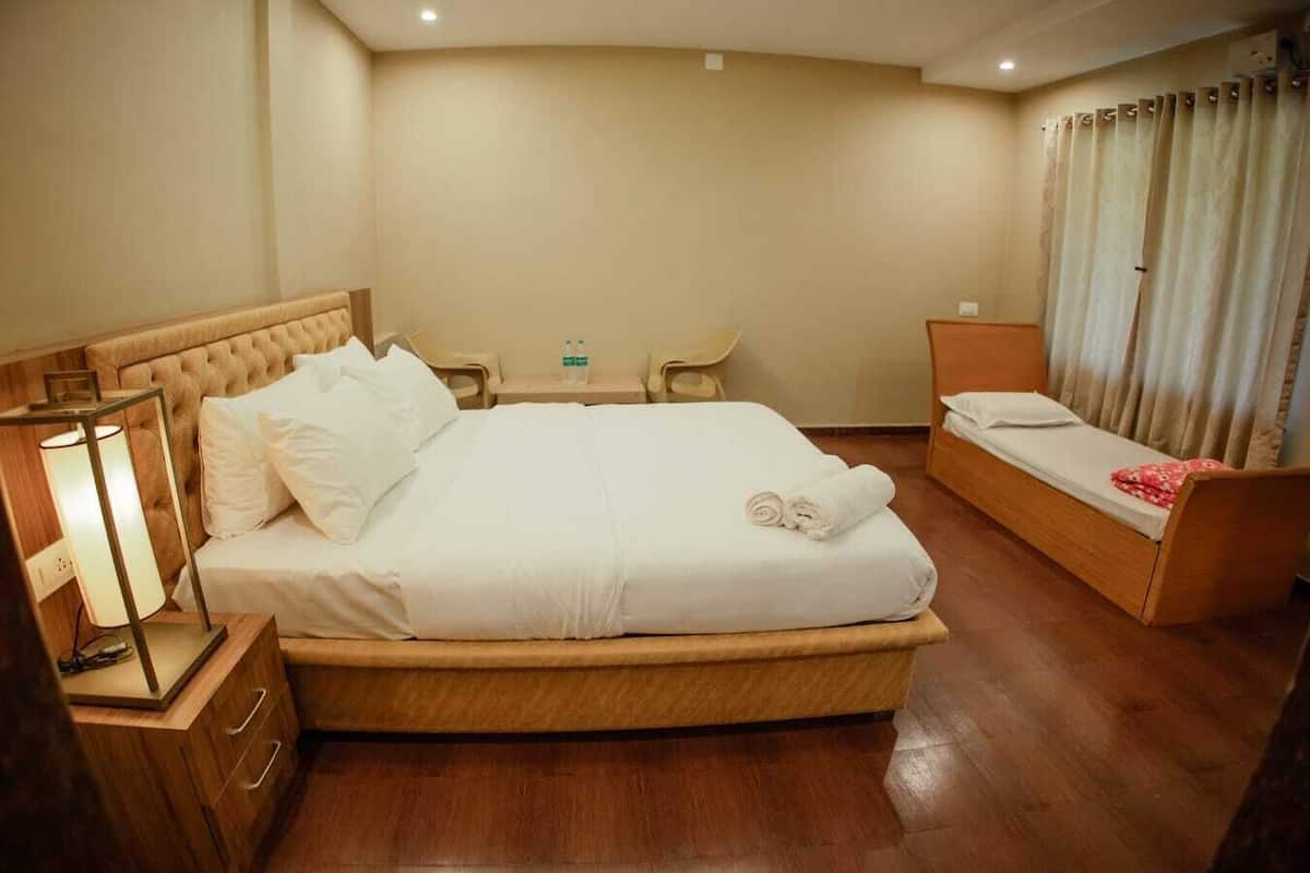 A hotel room with a large bed, bedside tables, a desk, and a chair.