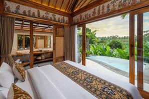 A bedroom with a large bed, wooden furniture, a view of a pool, and a tropical landscape. - Govala Usada Ubud Villa (Tegallalang)