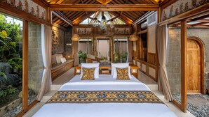 A spacious bedroom with a large bed, wooden ceiling beams, and a view of the outdoors. - Govala Usada Ubud Villa (Tegallalang)