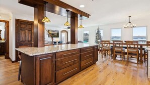 A spacious kitchen with a large island, wooden cabinets, and pendant lighting.