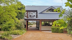 A modern two-story house with a covered patio area, surrounded by lush greenery. - Sailors Hill Retreat—Bushland Living by the Coast (Naturaliste)