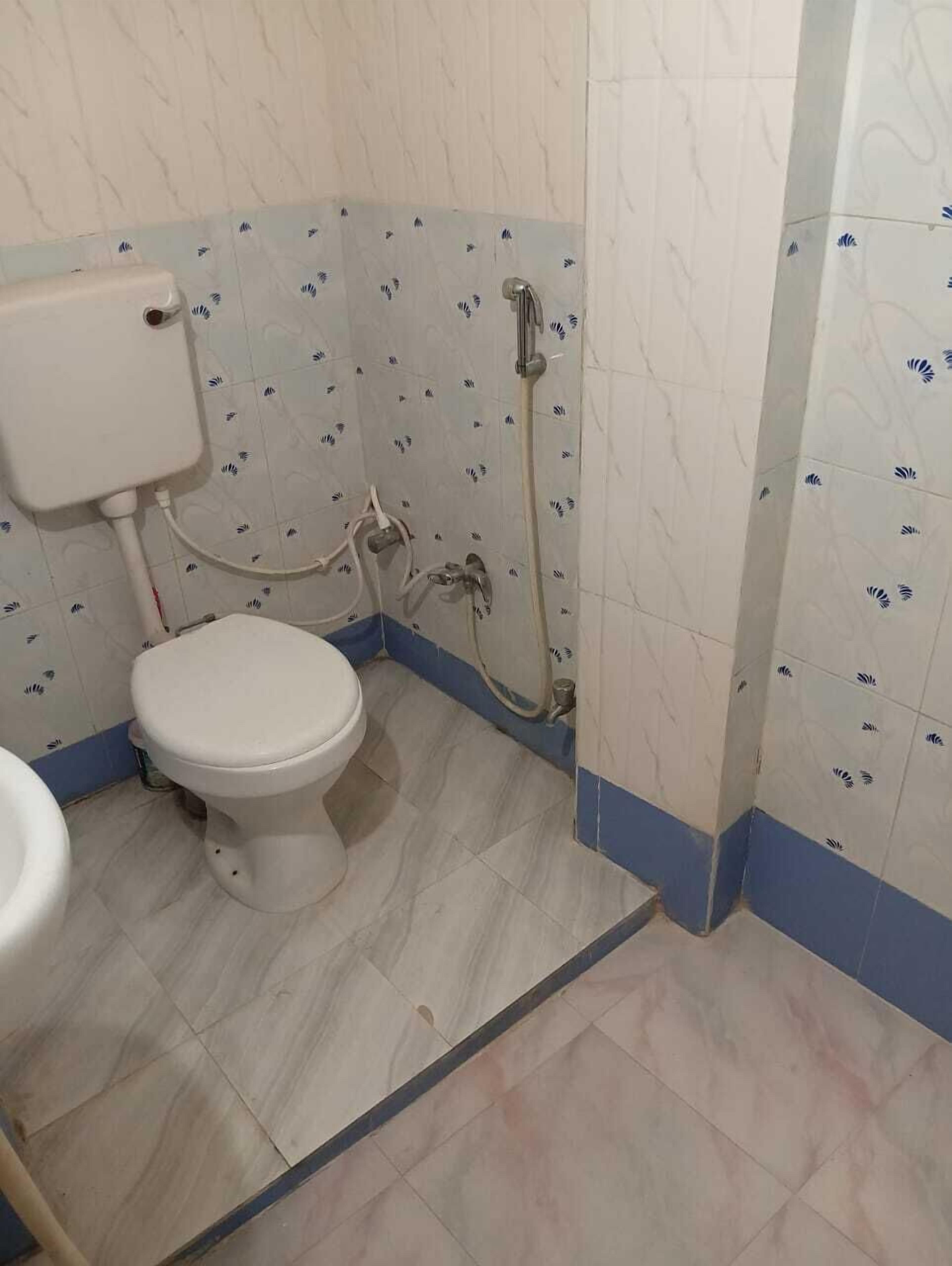 Une salle de bain avec des toilettes, un lavabo et une douche.