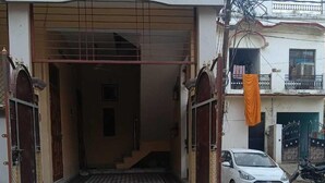 A gated entrance to a building with a metal gate and a ramp leading up to a door. - Shri Hari Sadan (Jhusi)