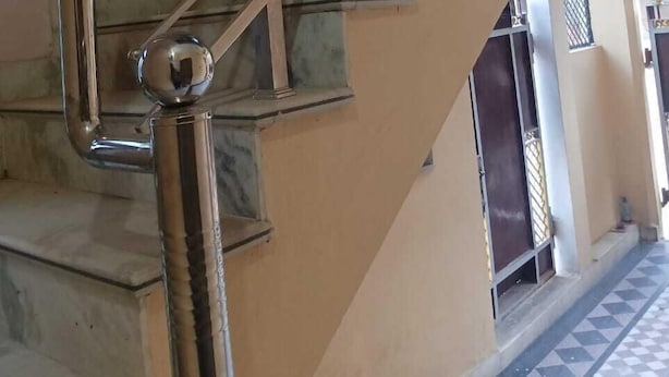 A staircase with metal handrails and a marble-like floor. - Shri Hari Sadan (Jhusi)