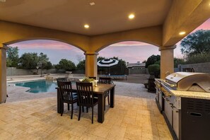 An outdoor patio with a pool, a barbecue grill, and a dining area with chairs and a table. - Naranja Grove Ranch - Villa in Chandler (Chandler)