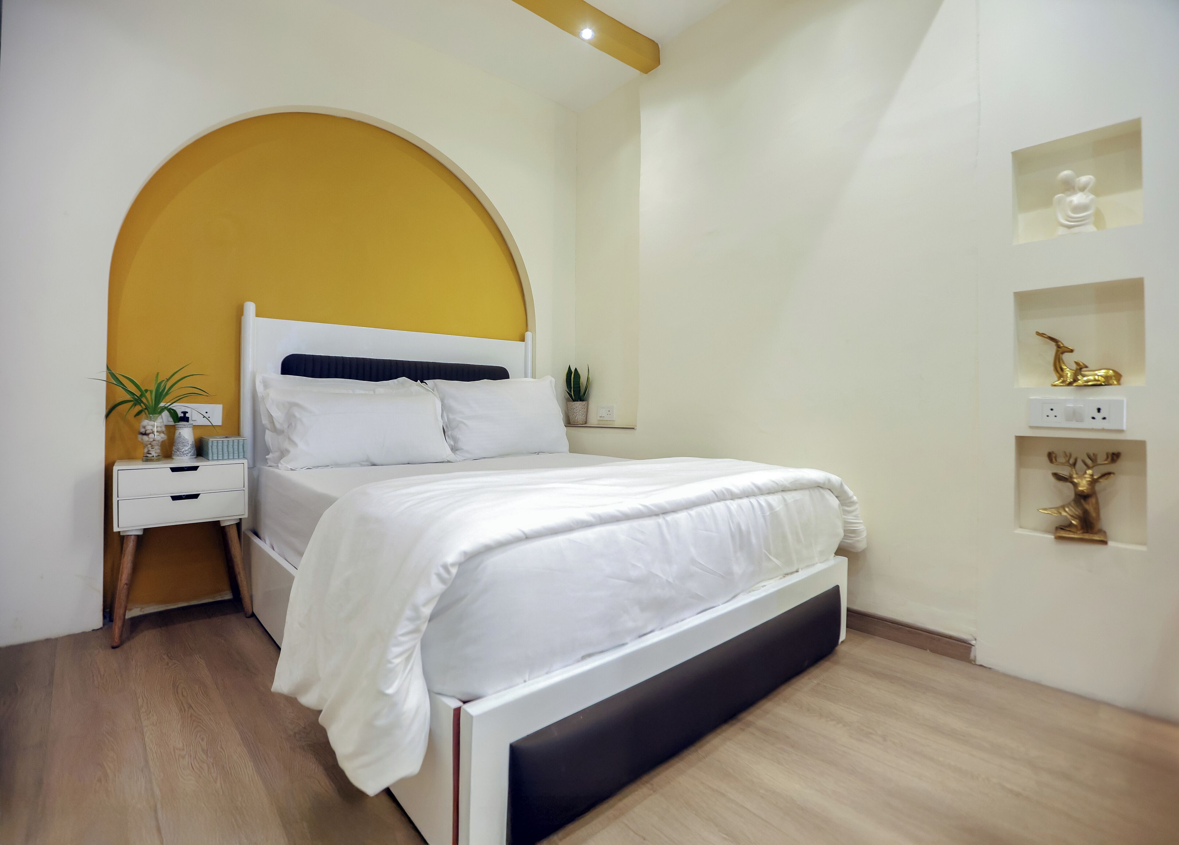 A modern bedroom with a bed, bedside tables, and decorative items.