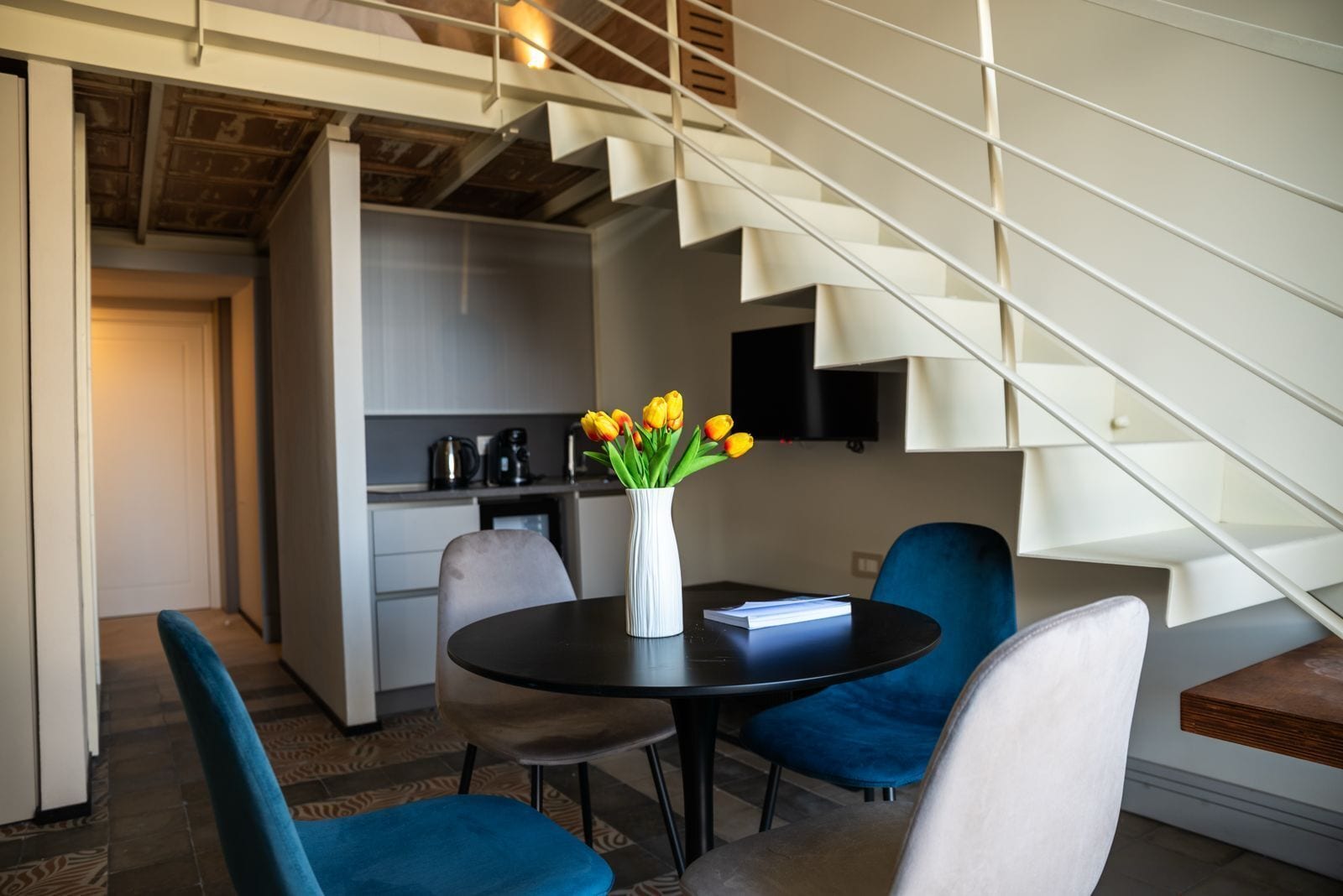 Ein zeitgemäßer Wohnraum mit Essbereich, Küche und Treppe.
