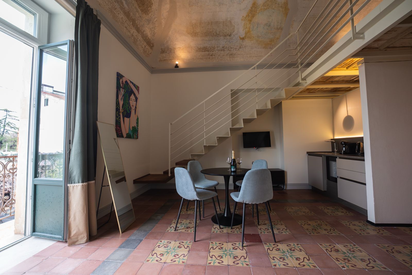 A modern interior with a staircase, dining area, and kitchen.