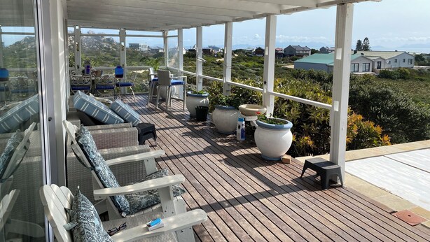 Una terraza techada al aire libre con asientos y plantas en macetas.