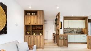 A modern living room with a sofa and wooden shelving unit. - Araliya (Kraków)