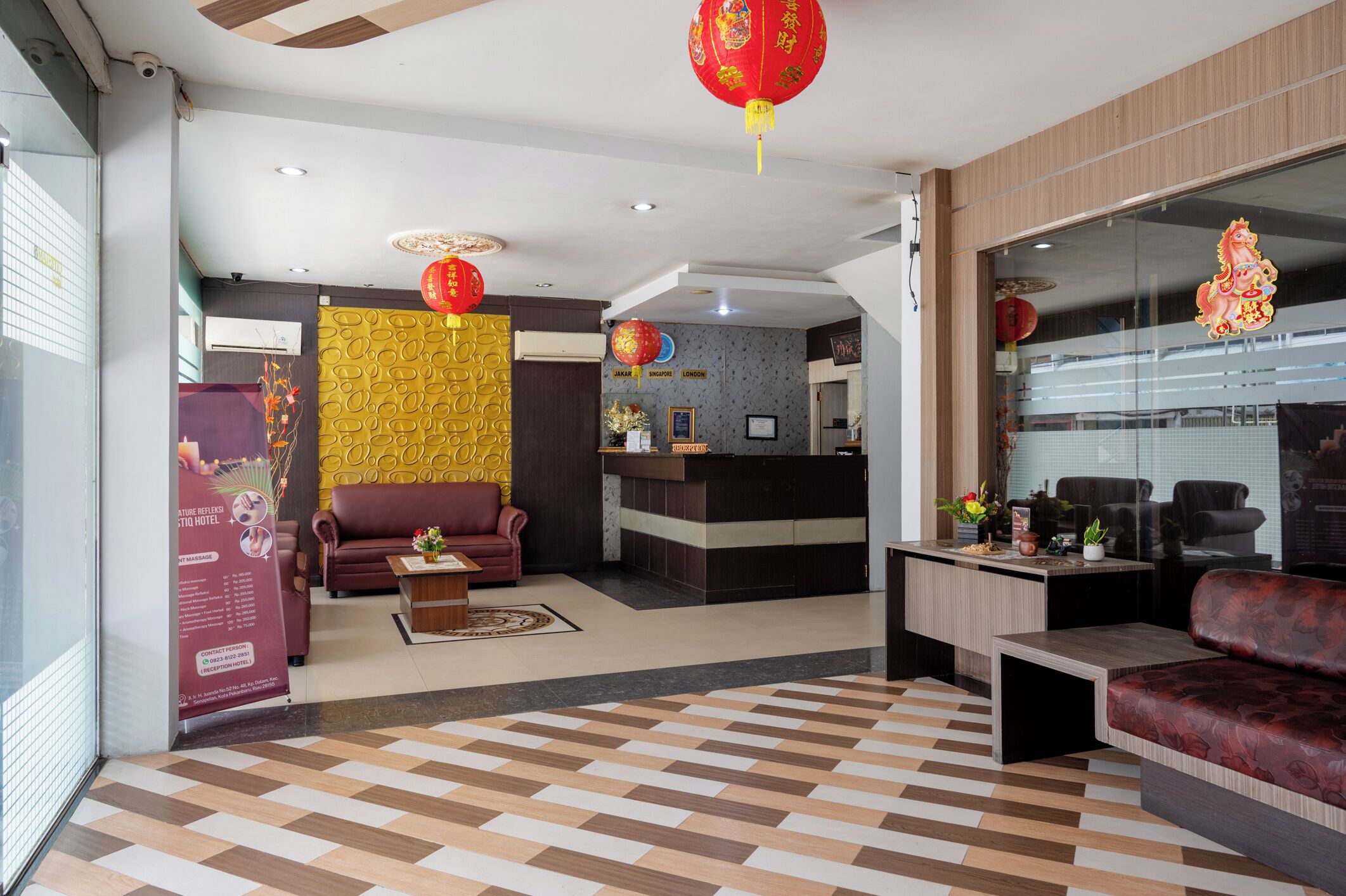 A hotel lobby with a reception desk, seating area, and decorative elements.