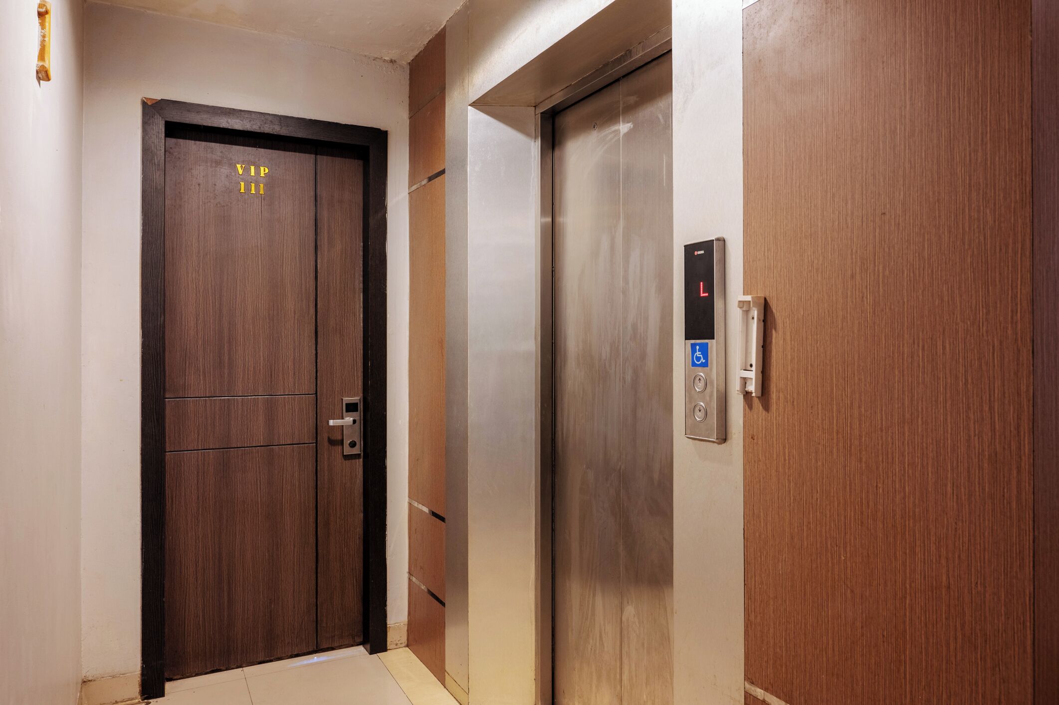 Een lift met een bedieningspaneel en een deur met de tekst 'VIP 111'.