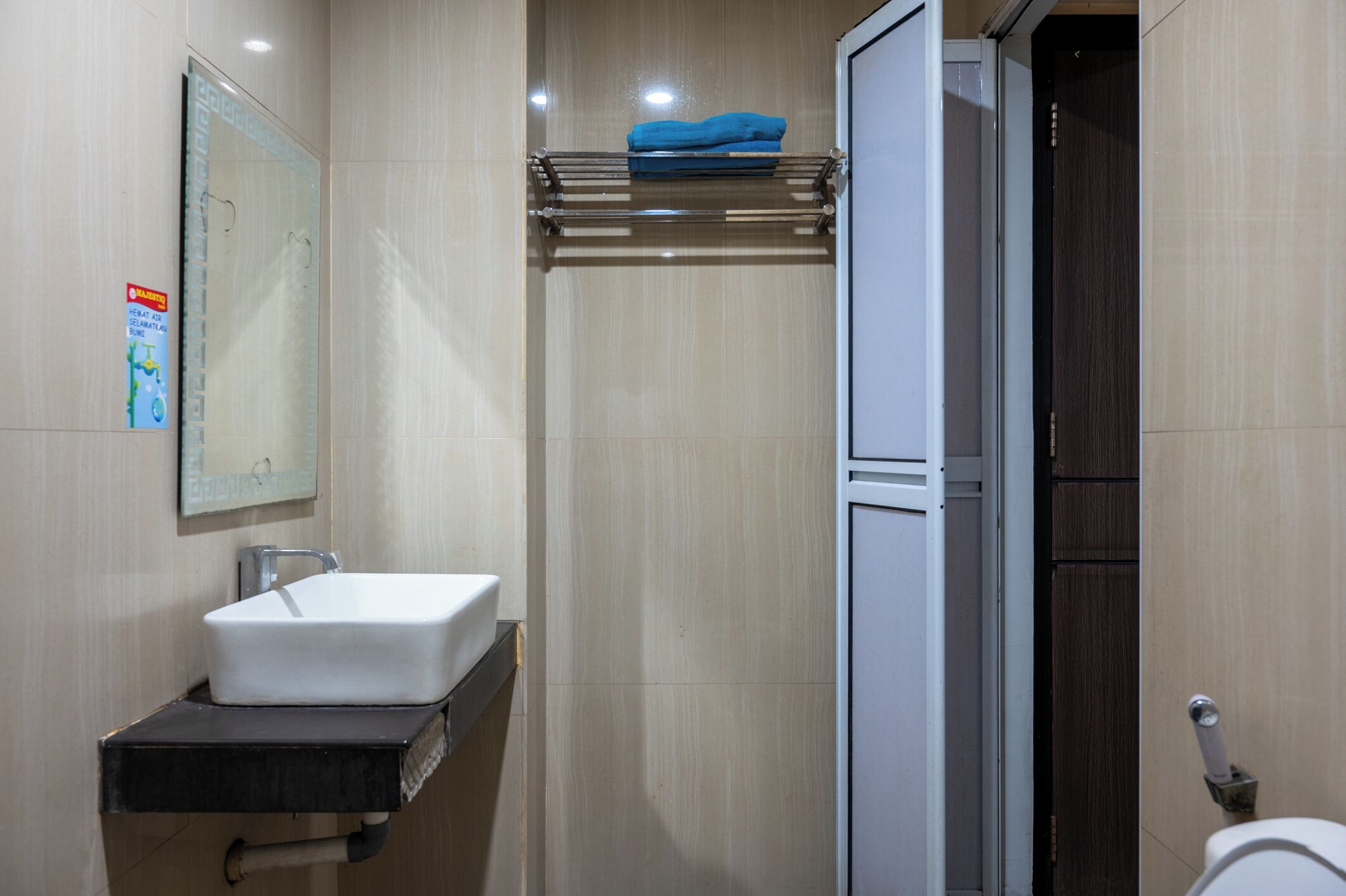 Un baño moderno con lavamanos blanco, toallero y retrete.