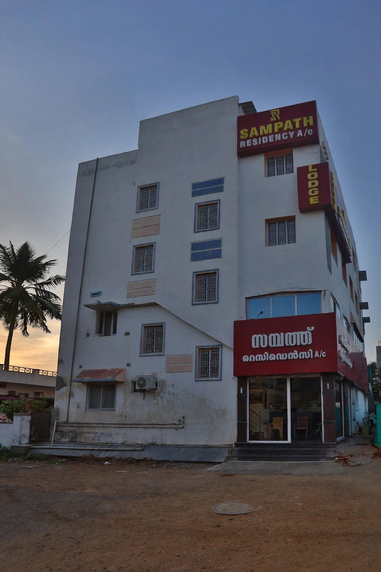 A multi-story building with signage for 'Sampath Residency A/c' and 'Mithra Lodge.'