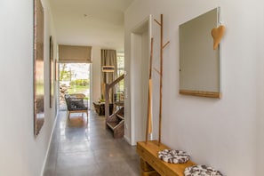 A hallway with a wooden bench, a mirror, and a staircase leading to a dining area. - Exclusive 5-star vacation home with sauna, whirlpool and garden in Karlshagen (Karlshagen)