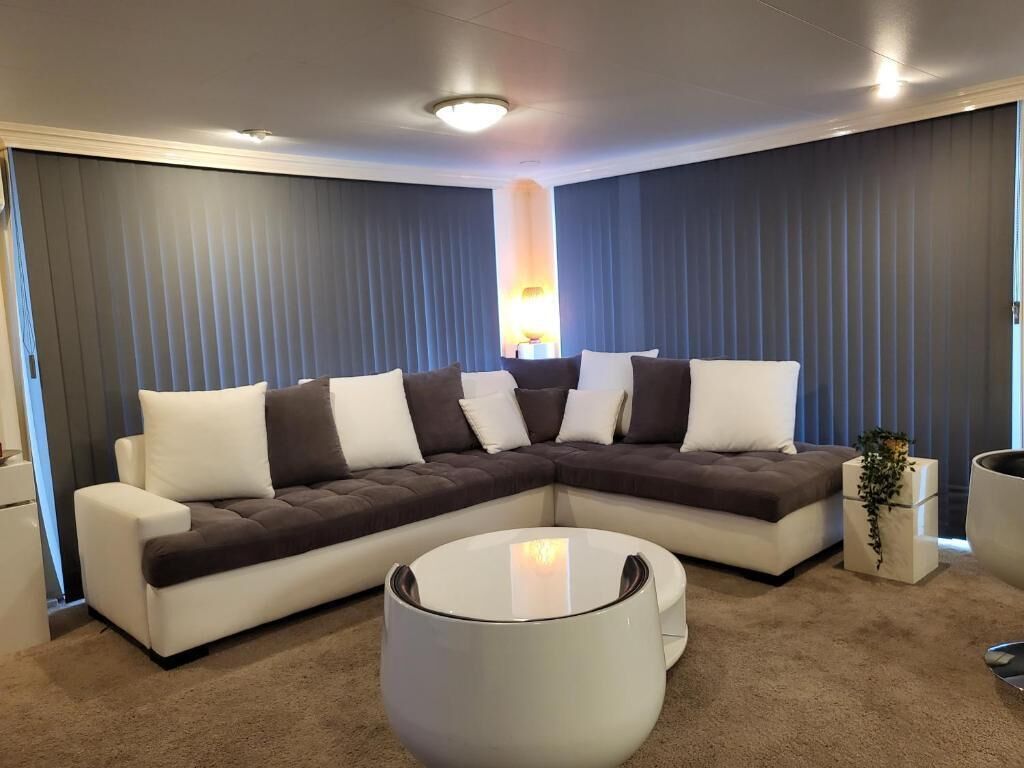 A modern living room with a sectional sofa, a round coffee table, and a lamp.