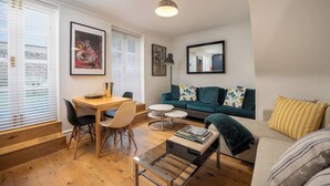 Ein modernes Wohnzimmer mit einem Holzesstisch, einer Couch und einem Couchtisch.