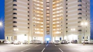 Ein mehrstöckiges Hotel mit einer zentralen Atriumlichtkuppel und einem Parkplatz.