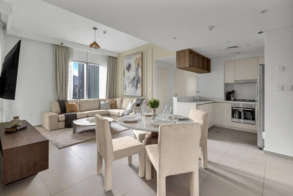 Una sala de estar moderna con sofá, mesa de comedor y zona de cocina.