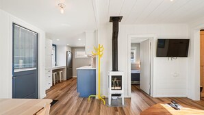 Uma cozinha moderna com ilha central, fogão embutido e área de refeições com mesa de madeira.