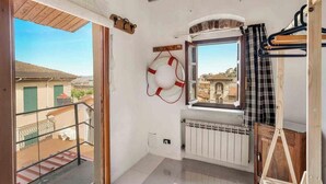A balcony with a view of buildings, a life preserver hanging on the wall, a radiator, and a wooden ladder. - Welcome to La Goletta, your holiday home on the third and top floor of a quiet building in La Spezia. This cozy two-room apartment is perfect for families, couples or small groups of friends.🛏 Sleeps up to 4 people with a double sofa bed in the living (La Spezia)