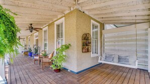 A covered porch with wooden flooring, white-framed windows, and a ceiling fan. - Pensacola • 1BR • Sleeps 2 • Close to Downtown (Pensacola)