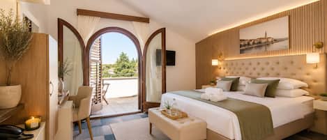 Habitación de hotel con cama, escritorio, silla, mesita con bandeja y vistas al exterior.