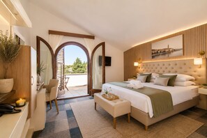 A hotel room with a bed, a desk, a chair, a small table with a tray, and a view of the outdoors. - Hotel Villa Vrsar (Vrsar)