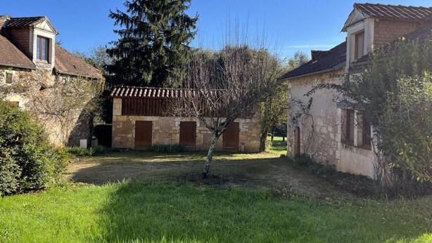 A courtyard with stone buildings, a large tree, and a grassy area. - Périgord Cottage with Garden, WIFI & Pets Welcome (Sorges et Ligueux en Périgord)