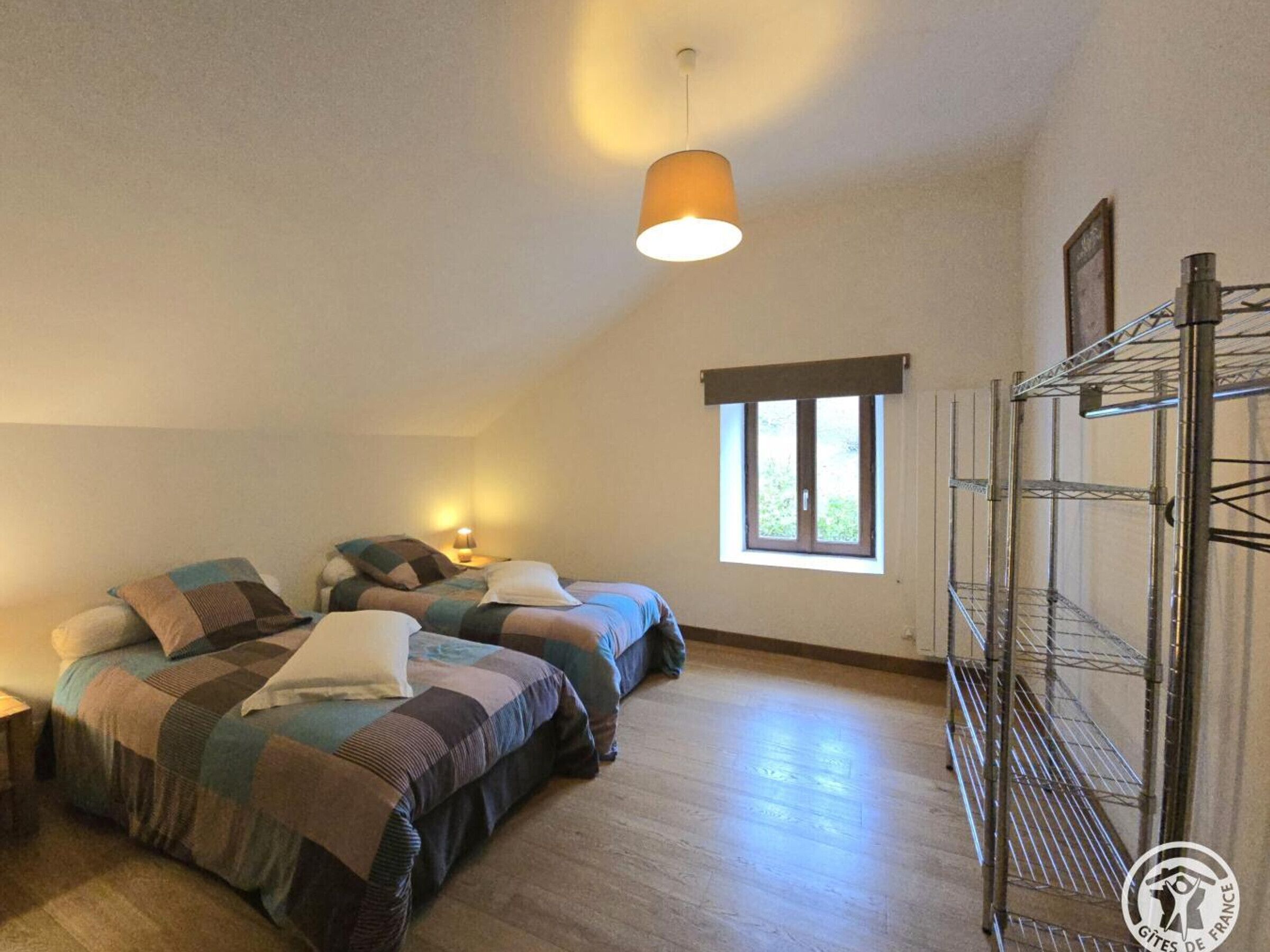 Ein Zimmer mit zwei Betten, einem Fenster und einem Etagenbett.