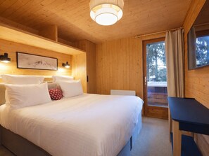 Ein Schlafzimmer einer Holzhütte mit Bett, Nachttisch und einem gerahmten Bild an der Wand.