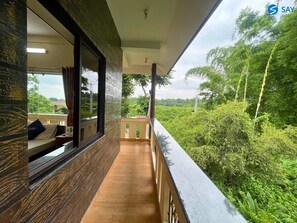 A balcony with a wooden floor and a view of lush greenery. - Say Resort Morning Glory (Mal)