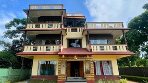 A multi-story building with a central entrance, balconies, and a tiled roof. - Say Resort Morning Glory (Mal)