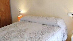 Una camera da letto con un letto, un comodino, una lampada e una presa a muro.