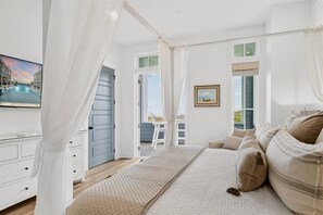 A bedroom with a bed, a TV, a window, and a balcony. - Casa de Playa – Gulf-Front Luxury Estate with Sweeping Views (Port Aransas)