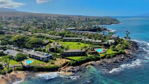 An aerial view of a coastal resort with multiple buildings, a swimming pool, and a rocky shoreline. - Walk to Beach and Dining + AC - Napili Shores D224 - Updated Studio (Lahaina)