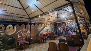 Un restaurant situé à l’intérieur, doté d’un haut plafond, d’un sol à carreaux et d’une décoration rustique.